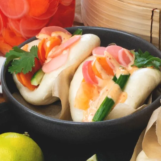 Fluffige Bao Buns mit knackigem Gemüse und würziger Sriracha-Mayo – einfach, frisch und voller Geschmack!
