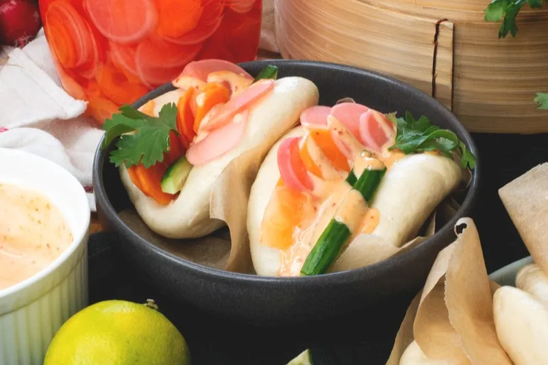 Fluffige Bao Buns mit knackigem Gemüse und würziger Sriracha-Mayo – einfach, frisch und voller Geschmack!