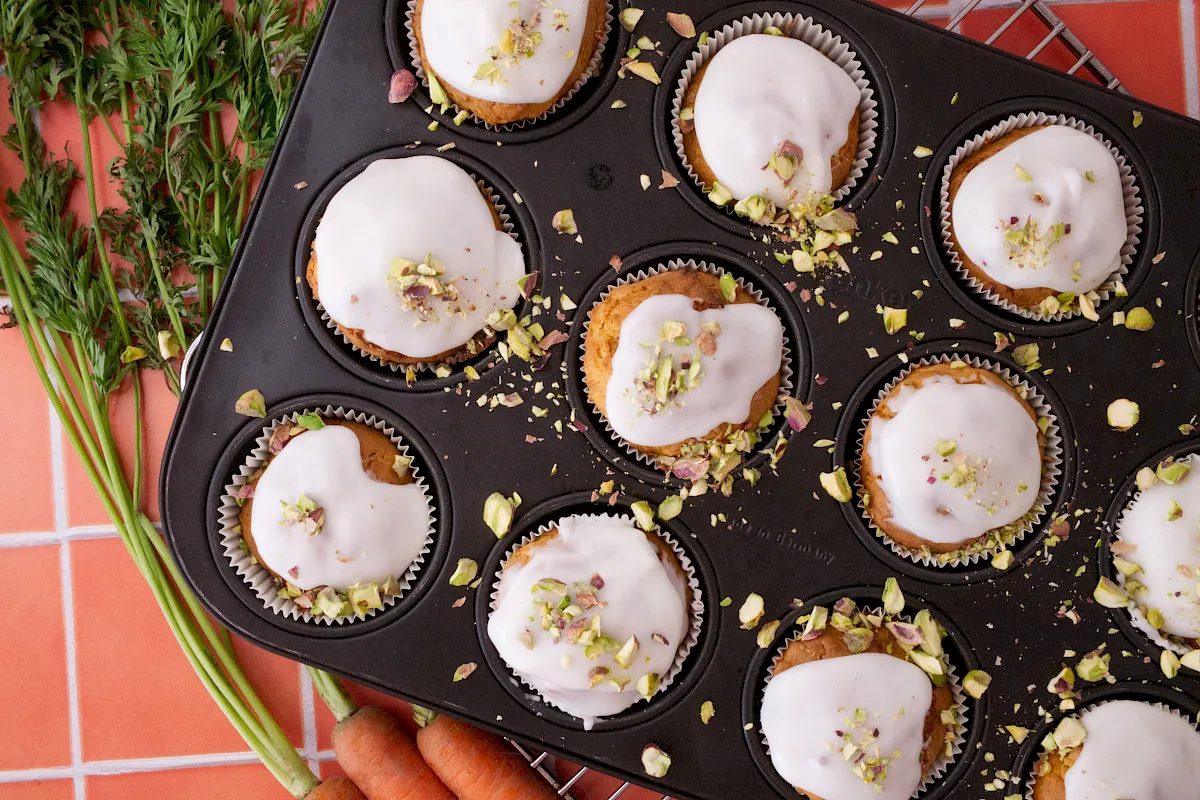 Saftige Karottenmuffins mit feiner Zitronenglasur und einem zarten Crunch aus Pistazien